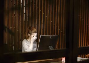 ノートパソコンの前に座る女性