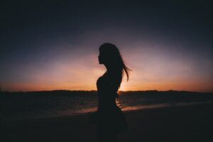 海岸近くに立つ女性の
